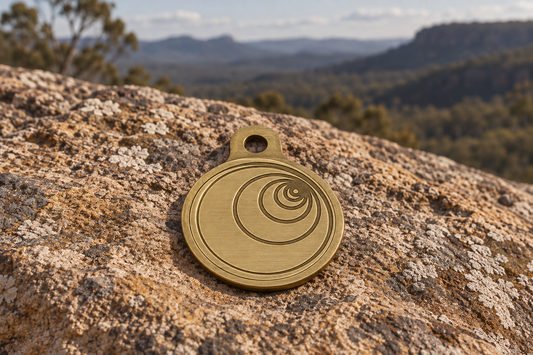 Ground pendant in brushed gold, front showing spiral geometry